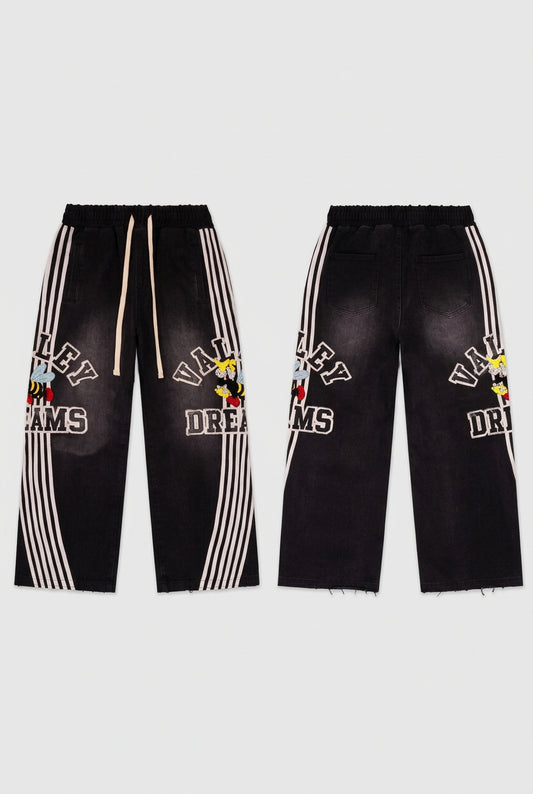 Black track pants with white side stripes and graphics